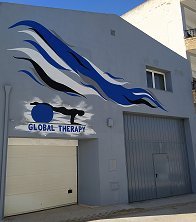 Fachada del centro Global Therapy, con el logo de la pelota azul pintado sobre la puerta